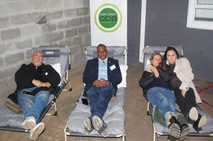 Testing out the beds at the Safe Sleeping Zone, from left are the Haven Night Shelter board member, Ezra October, their CEO, Pastor Shaddie Valayadum, Streetscapes representative, Jesse Laitinen, and CCID Social Development Manager, Tara Gerardy-Bissolati.
