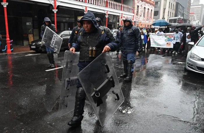 South African Police Service officers maintain a visible presence as anti-undocumented migrant groups march through Cape Town's CBD on Wednesday.