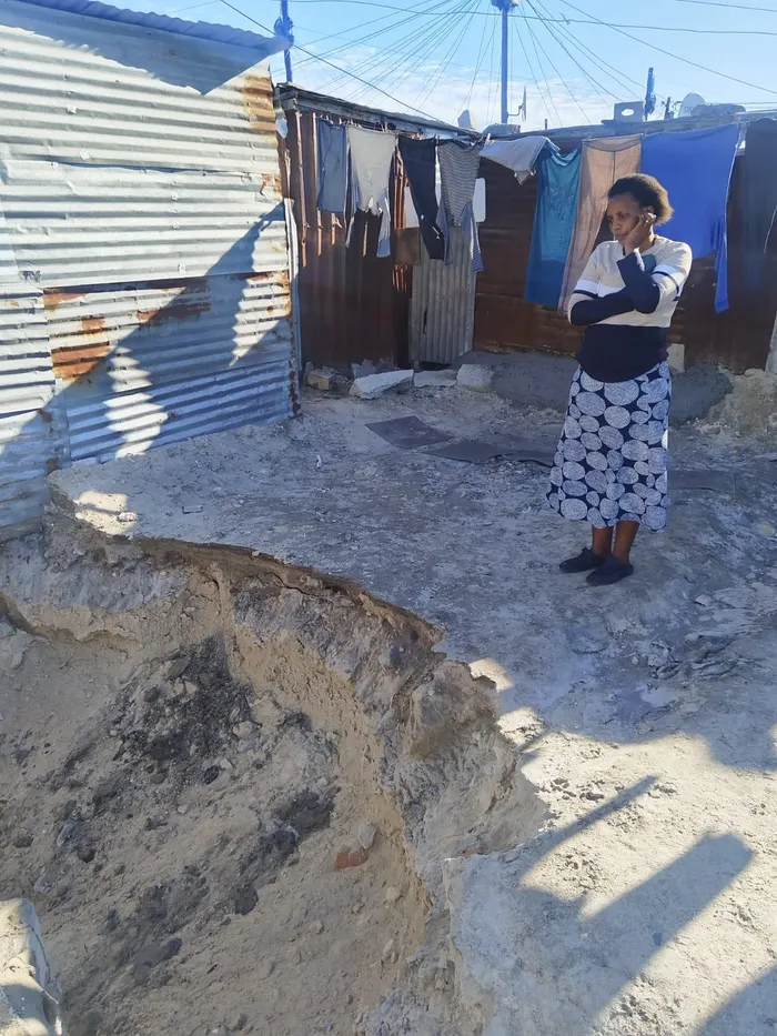 An emotional Khayelitsha resident, Phumeza Somdaka, looking at the hole caused by the sewer spill near her home.