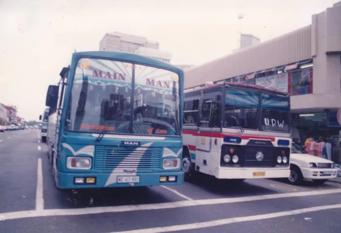Phoenix bus owners kept up with the latest designs and trends to make their buses appealing to passengers. Here are the Mayville Coach Lines bus 'MAIN MAN' and the Springfield Safari Tours bus Jenny 2, in the Durban CBD, circa 1990s. 
