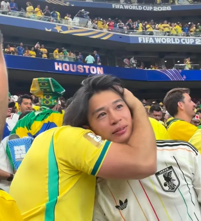 A Brazilian fan comforts a Japanese fan during the 2026 Fifa World Cup.