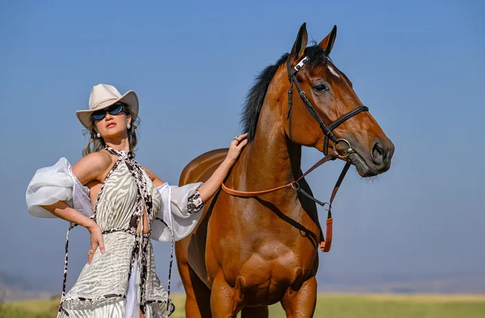 Dressed by invited Hollywoodbets Durban July designer Katherine Kidger, Anlia Etzebeth showcases a “Country Allure” inspired look alongside Hollywoodbets Durban July runner Wish List. 