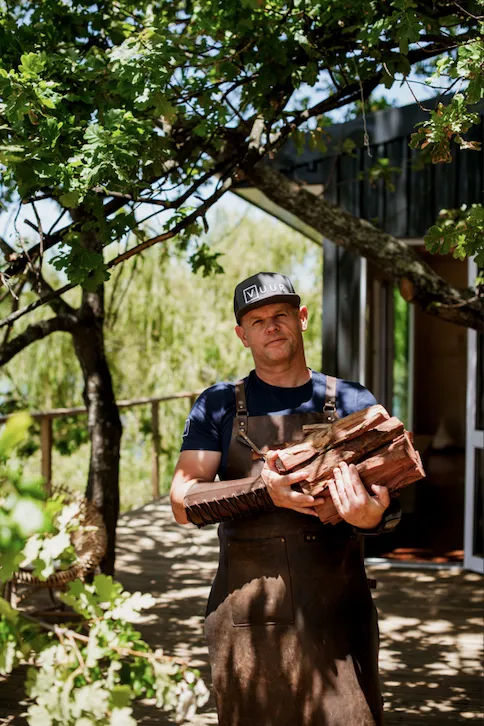 Chef Shaun Scrooby of VUUR holding firewood outside the restaurant
