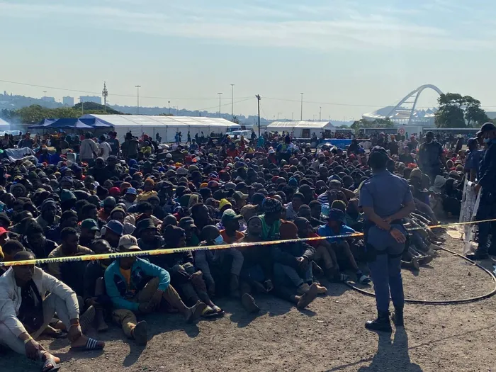 Police operations in Durban lead to the arrest of a wanted foreign national amidst rising concerns over overcrowding at a local camp housing thousands of undocumented immigrants.