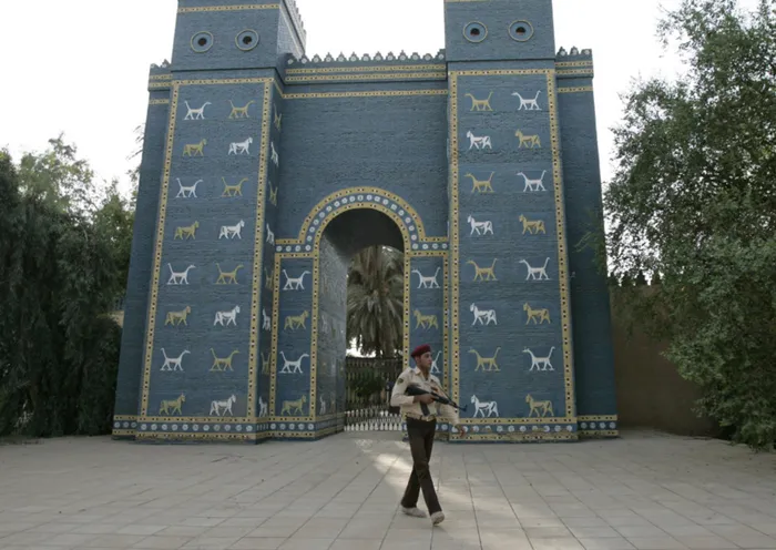 An Iraqi armed soldier walks in front of Ishtar Gate of ancient Babylon.