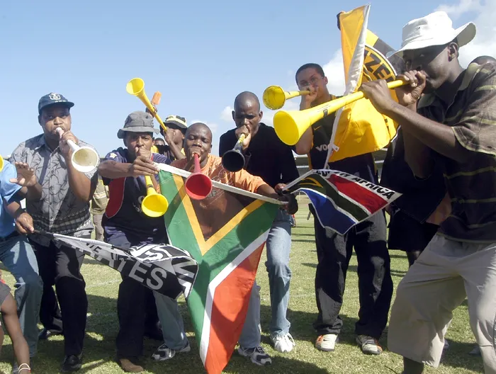 Soccer fans blow their vuvuzela horns in anticipation of the announcement by Fif