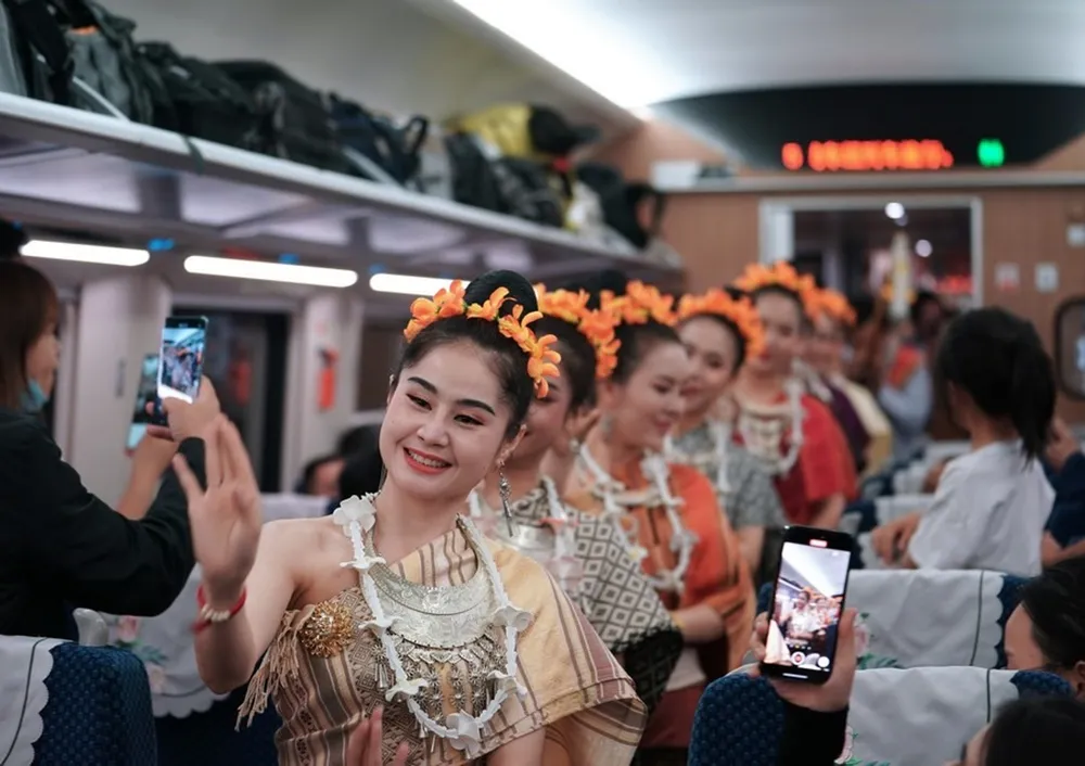 Lao staff members perform at the first cross-border passenger train from Kunming in southwest China's Yunnan Province to the Laotian capital Vientiane on April 13, 2023. Xinhua/Xing Guangli