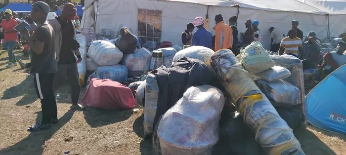 Displaced Malawian residents secure their belongings as they prepare to be transported back home following  anti-immigration protests in Durban. 