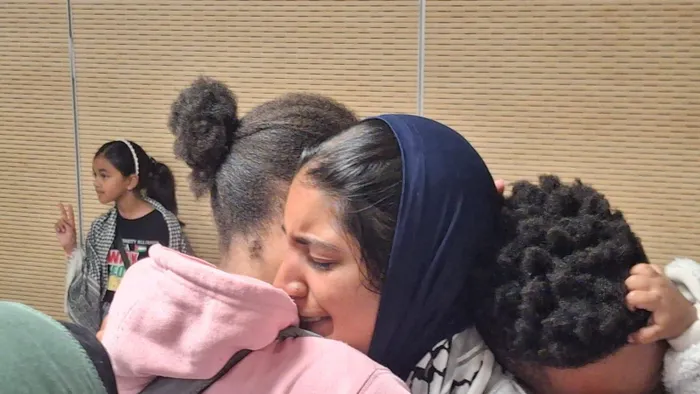 Overwhelmed with emotion, Hajar Kagiso Al Thaira Ahjum Mathee is embraced as she arrives at O.R. Tambo International Airport, after her traumatic experience of detention during the Gaza flotilla mission.