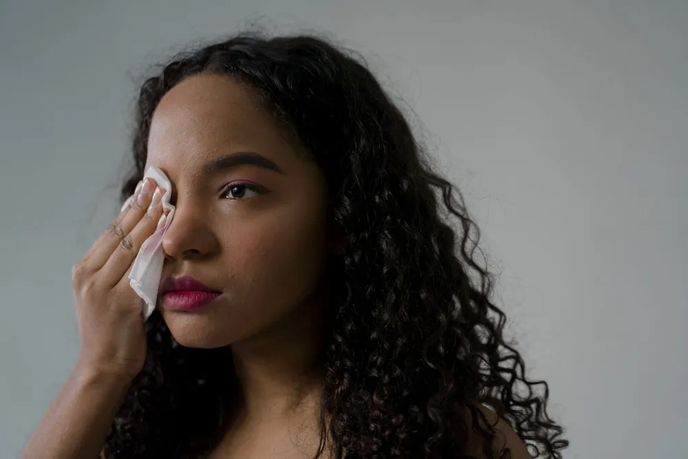 Young woman removing make-up using a facial wipe