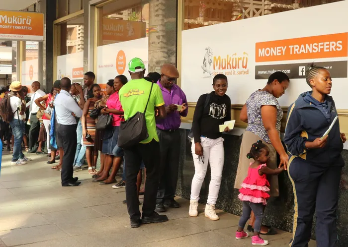 People queue to withdraw US dollars from a money transfer shop in Harare, Zimbabwe. President Emmerson Mnangagwa hailed 2022 as the ‘Year of Economic Growth’, but persistent inflation is hampering the country from flourishing. Picture: Philimon Bulawayo/Reuters