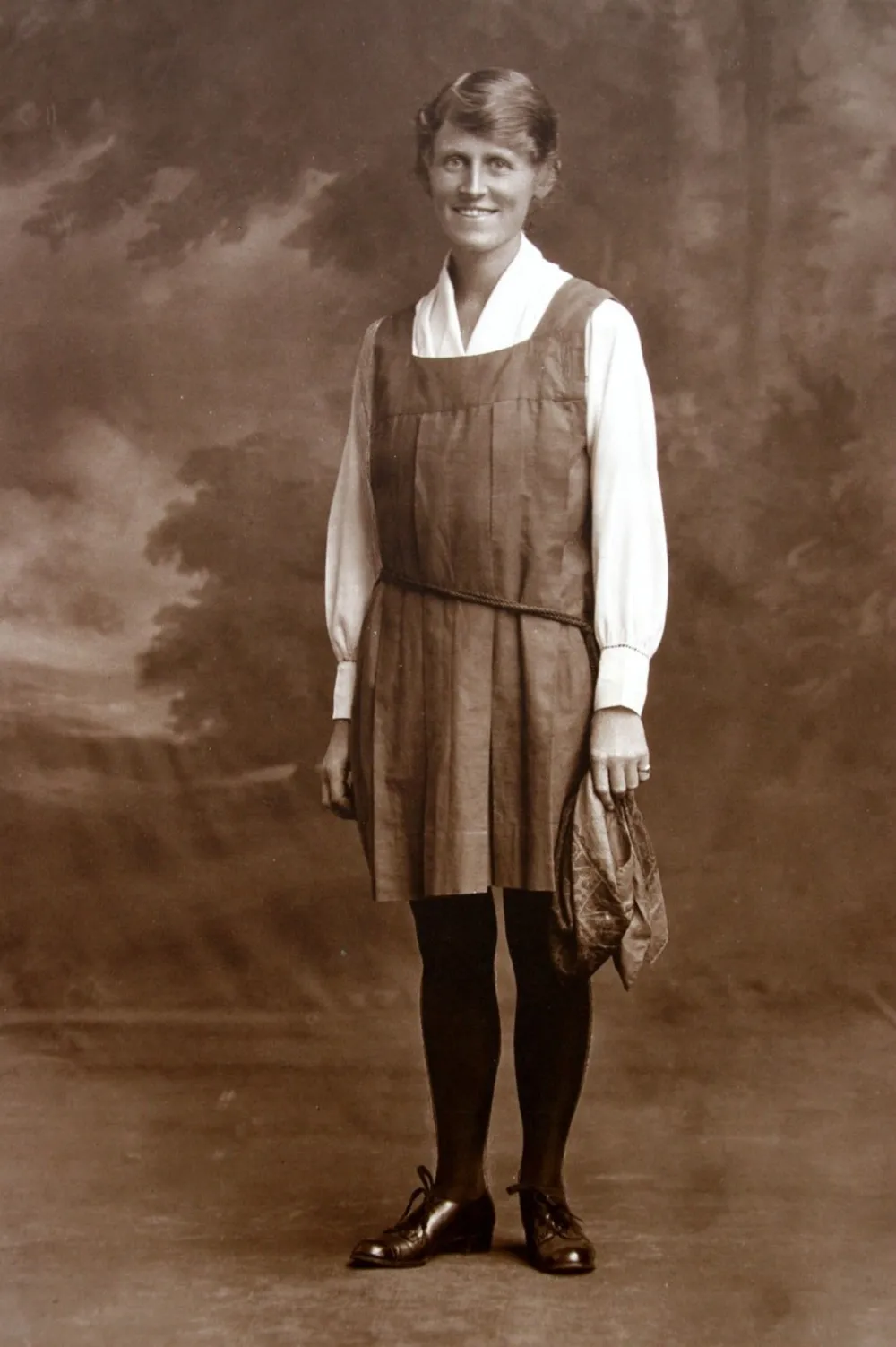 Portrait of Frances Elizabeth Hay smiling, in a pinafore dress, black tights and lace-up shoes. 