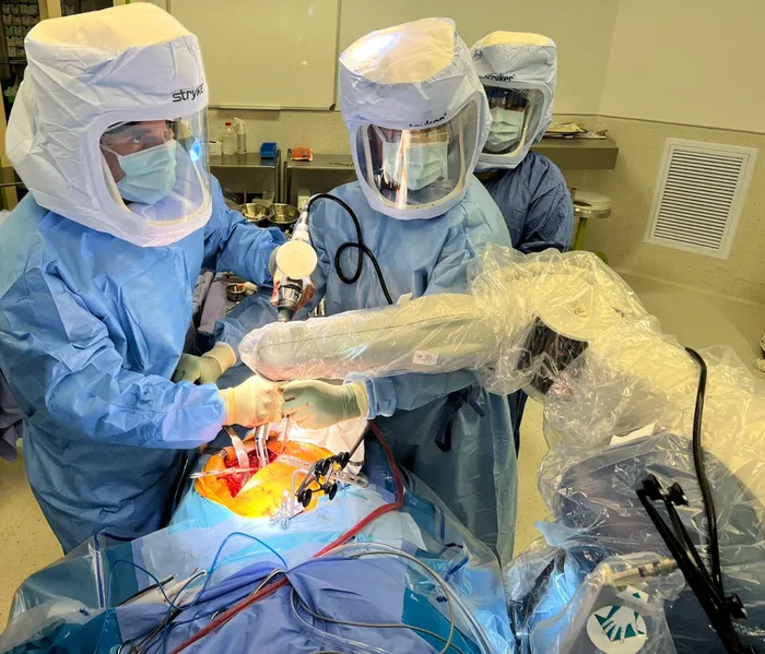 Dr Wian van der Merwe, left, an orthopaedic surgeon practising at Netcare Pretoria East Hospital, performs knee replacement surgery with the advanced Mako SmartRobotics system, assisted by registered nurse Madri van der Sandt, centre, and enrolled nurse Dineo Mokone. Picture: Supplied