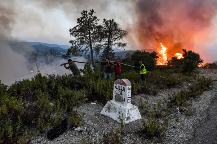 Firefighters attempt to extinguish a raging forest fire near the town of Melloula in northwestern Tunisia close to the border with Algeria. Picture: AFP