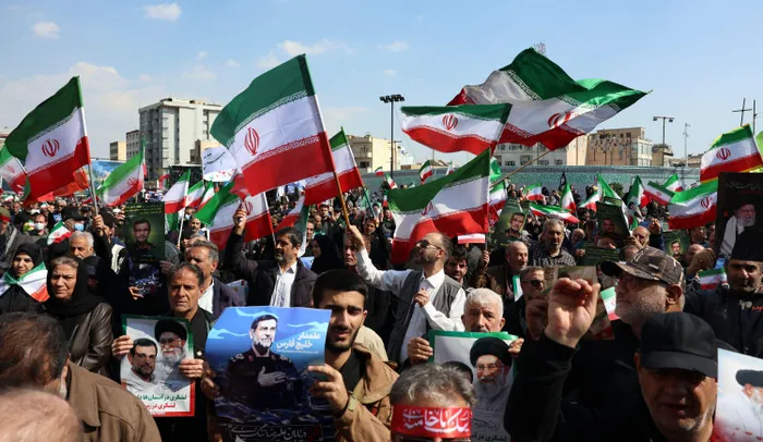 People wave Iranian flags while attending the funeral of Alireza Tangsiri, commander of the Iranian Revolutionary Guards' navy alongside others killed in US-Israeli strikes on Iran at Enghelab Square in Tehran.