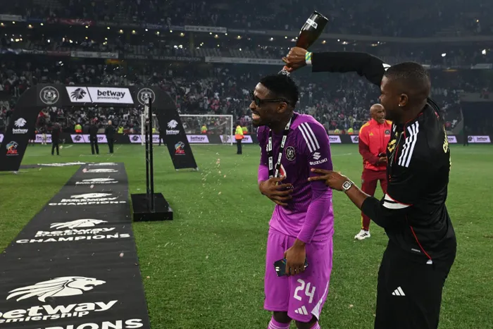 Orlando Pirates goalkeeper Sipho Chaine is drenched with champagne after they won the Betway Premiership. 