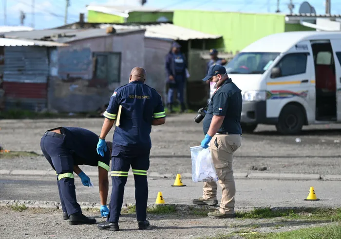 Police and forensic officials at the scene of a suspected taxi-related shooting in Nyanga, where four men were killed and two others were critically injured on Tuesday morning. 