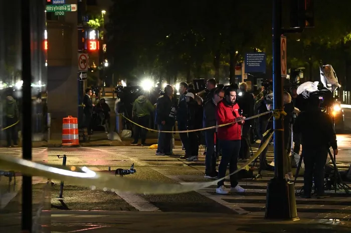 Members of the media stand outside the area where a shooting occured earlier at 18th and Pennsylvania Avenue near the White House in Washington, DC, on May 23, 2026.