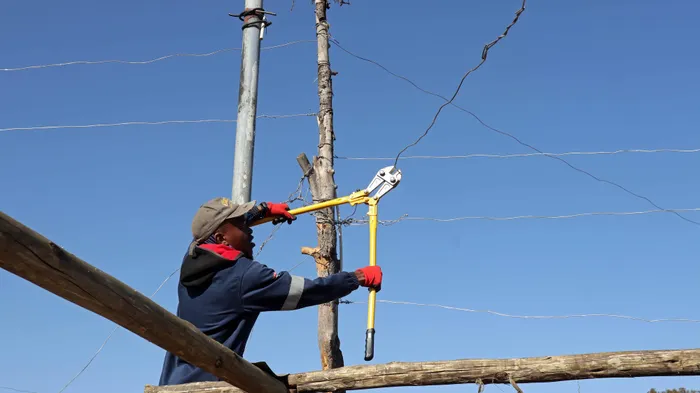 A City power official cuts illegal electricity connections in Slovo informal settlement near Mayfair. Picture: Timothy Bernard/African News Agency (ANA)