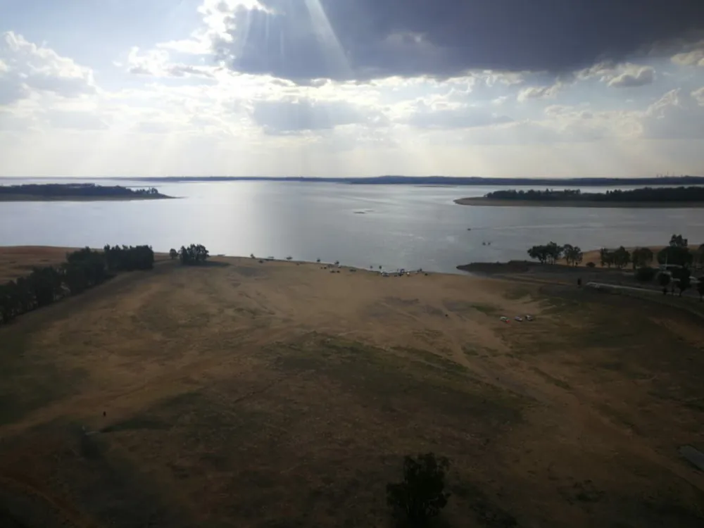 Part of a large water dam and the shoreline.