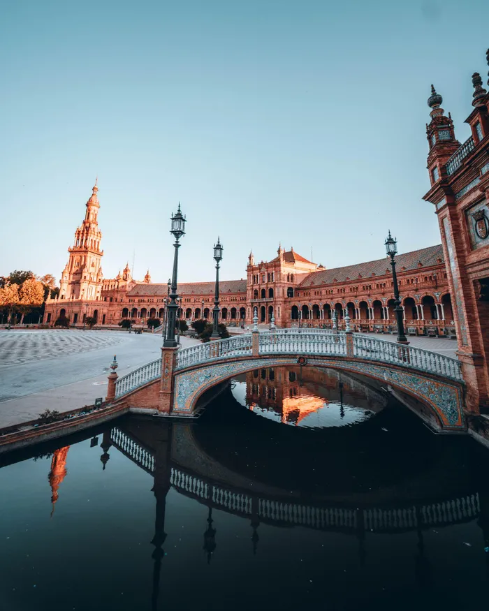 At sunrise, explore the stunning architecture of Plaza de España in Seville, Spain.