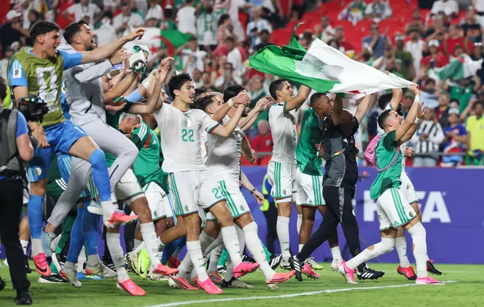 Algerian players celebrate their progression to the Round of 32 at the Fifa World Cup.