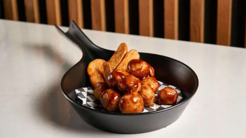 Savour the comfort of beef meatballs in rich onion gravy with crispy potato wedges