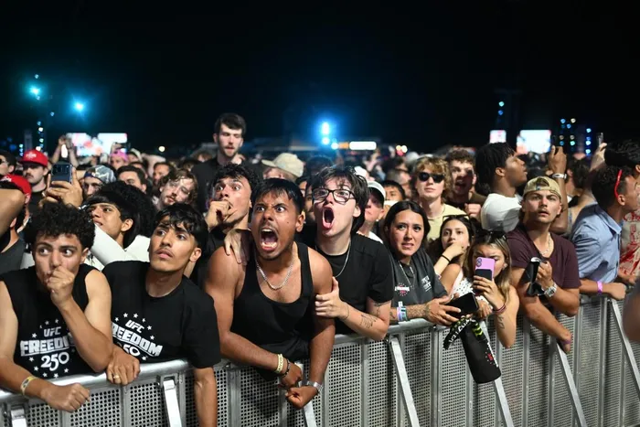 Fans react as they watch the "UFC Freedom 250" mixed martial arts event on The Ellipse, south of the White House in Washington, DC, June 14, 2026. 