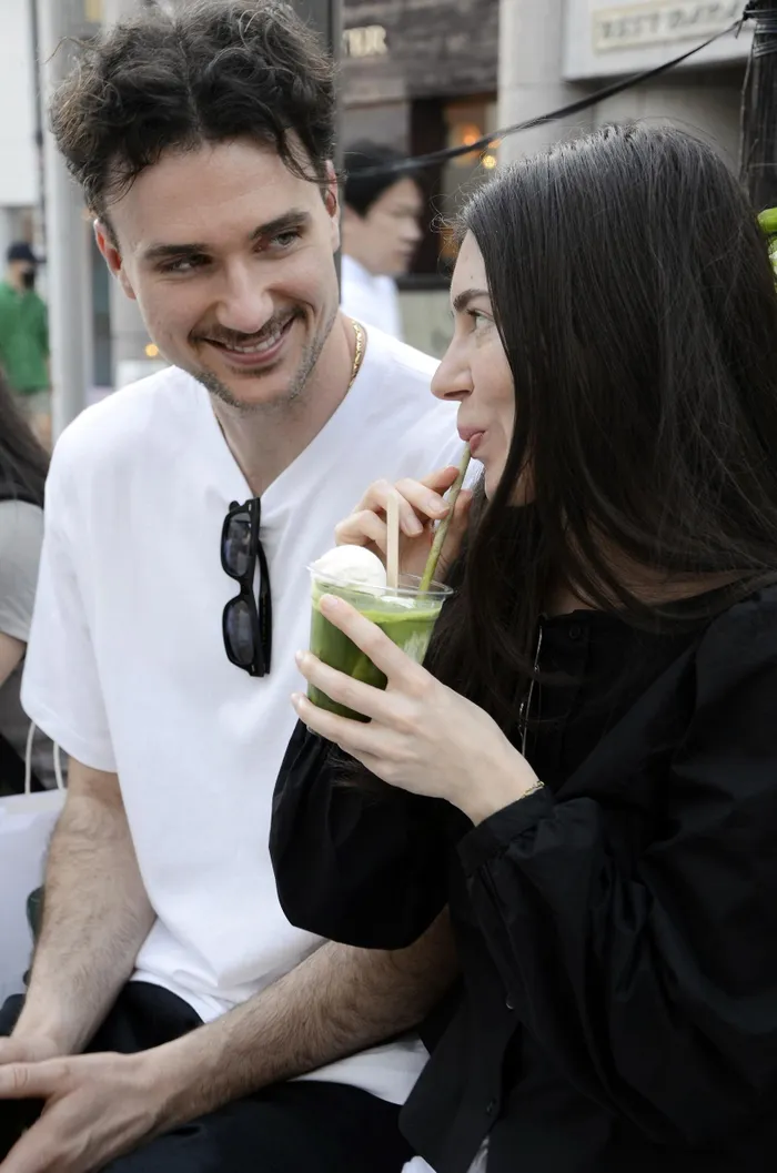 A foreign tourist drinks a matcha beverage in Shibuya Ward, Tokyo, in April. 
