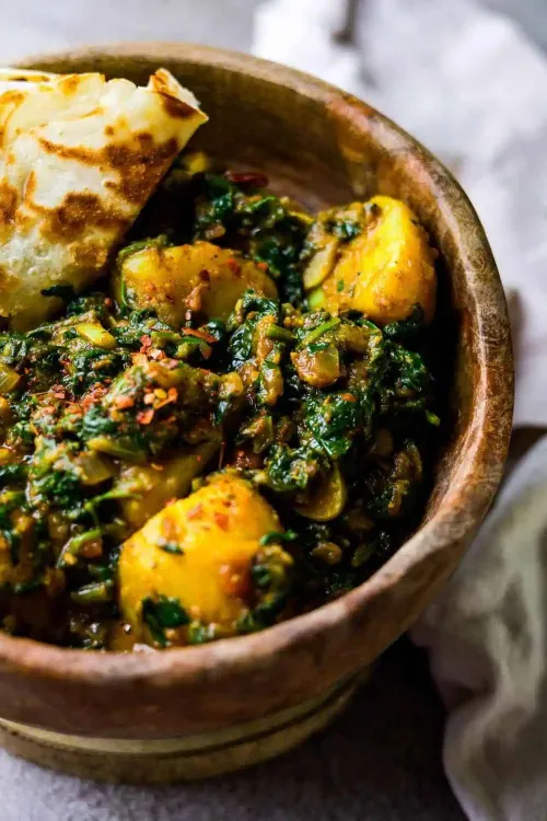 Spinach and potato curry served with naan