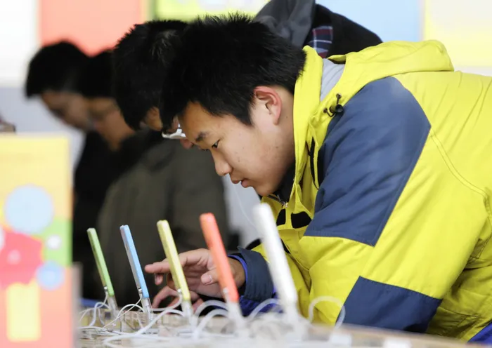 A customer tests an iPhone 5c at an Apple store in Beijing earlier this month. Apple's chief executive says sales in North America were weaker than expected in the holiday season, partly because the less-expensive iPhone 5c released last year isn't as popular as the higher-end iPhone 5s. Photo: Reuters