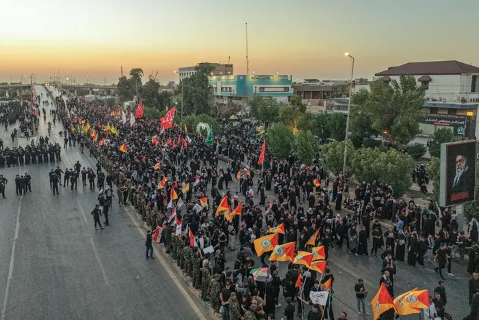 Mourners gather at Al-Kufa Intersection Bridge at the start of the funeral procession for Iran's slain supreme leader Ali Khamenei in Najaf.